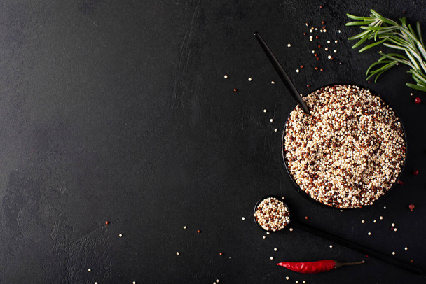 white and red quinoa grits in a black bowl, top view - Фото, зображення