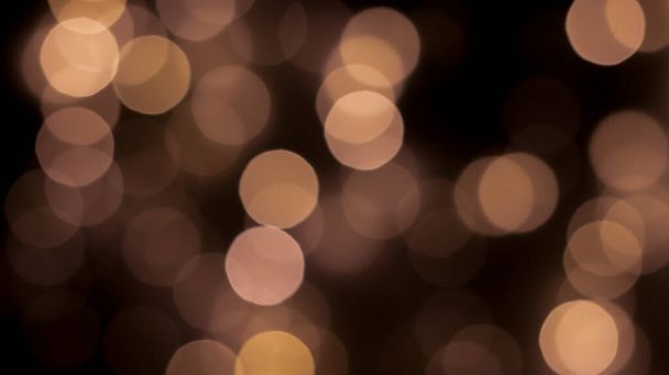 Bokeh festivo bonito em um fundo preto círculos dourados, efeito bokeh noite leve, desinflado. Cartão postal festivo, vista noturna. - Foto, Imagem