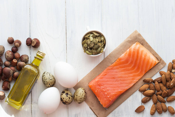 Selección de grasas insaturadas saludables, salmón, huevo, aceitunas, frutos secos y semillas - Foto, Imagen