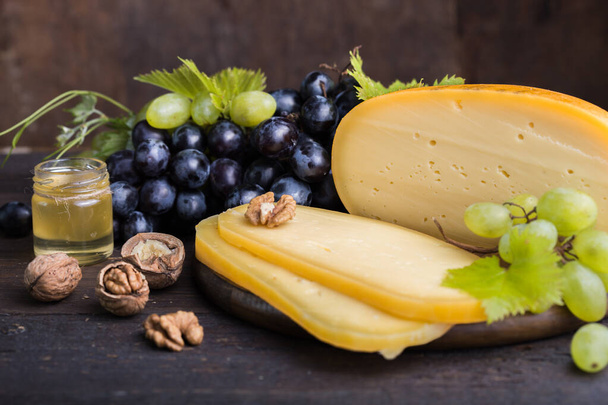 Голландский твердый сыр Maasdam или Emmentaler, с мёдом фруктов и винограда - Фото, изображение