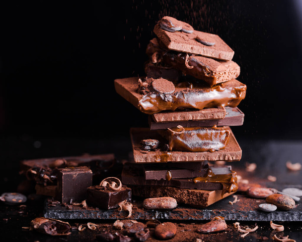 Çeşit çeşit çikolatalı şekerler. Çikolatalı şekerler. Koyu kahverengi arkaplan üzerinde Candy Design. Çeşitli çikolatalar. Şekerlemeci - Fotoğraf, Görsel