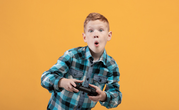 Ενθουσιασμένος αγόρι που παίζει βιντεοπαιχνίδι με joystick, αντίγραφο χώρου - Φωτογραφία, εικόνα