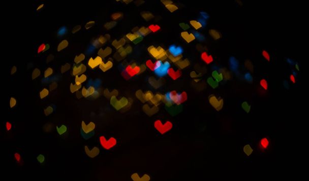 Прапор з різнокольоровими дезоктированими світловими садами у формі серця. Бокі на чорному тлі для використання в фоторедакторі. Чудовий кучерявий бокс. Магічне тло для нового року й Різдва. - Фото, зображення