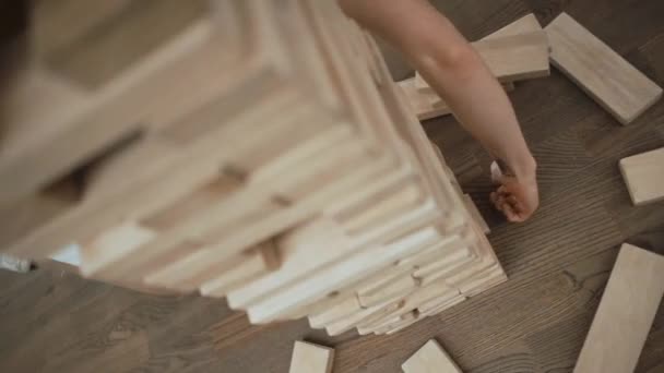 Un hombre juega juego de tablero de torre de bloque de madera para practicar la habilidad de estrategia - Imágenes, Vídeo