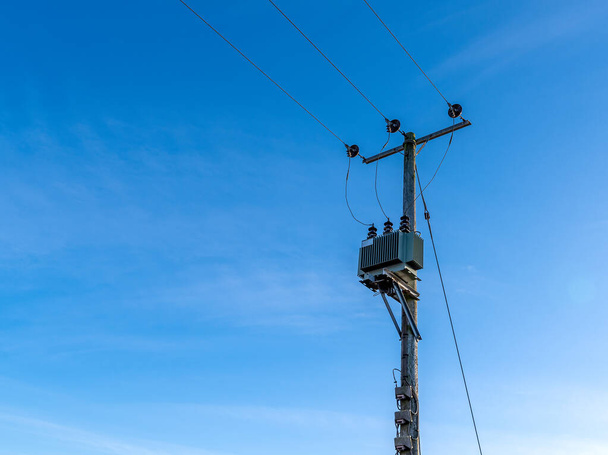 Wooden telegraph poles with wires and unsulators against a clear blue sky background - Photo, Image