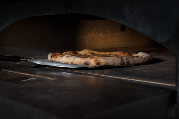 käsintehty pizza tulossa kotitekoisesta uunista - Valokuva, kuva