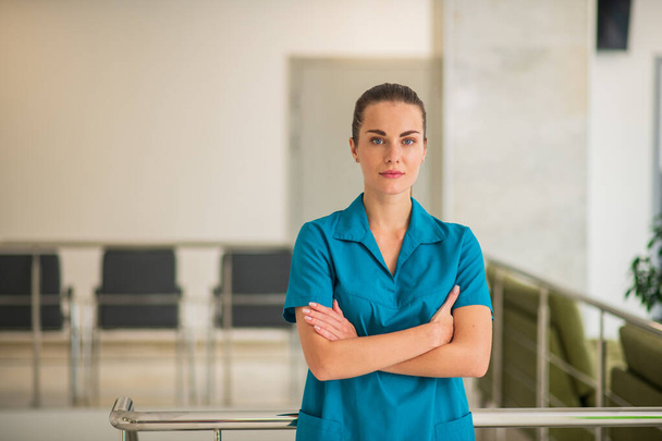 Pretty young female doctor in blue uniform looking determined - 写真・画像