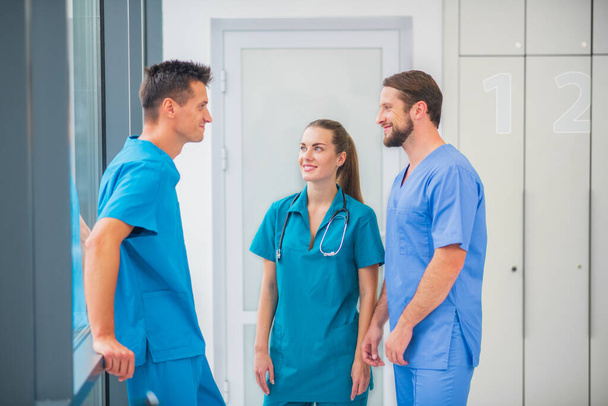 Group of doctors talking in the corridor and feeling positive - 写真・画像