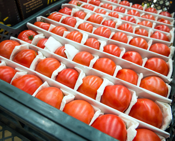 Una caja con filas bellamente dispuestas de tomates maduros - Foto, Imagen