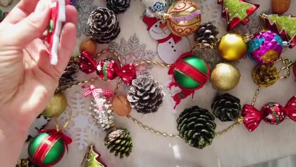 Glas, plastic, kerstboom decoraties op tafel. Vrouwelijke handen. Close-up - Video
