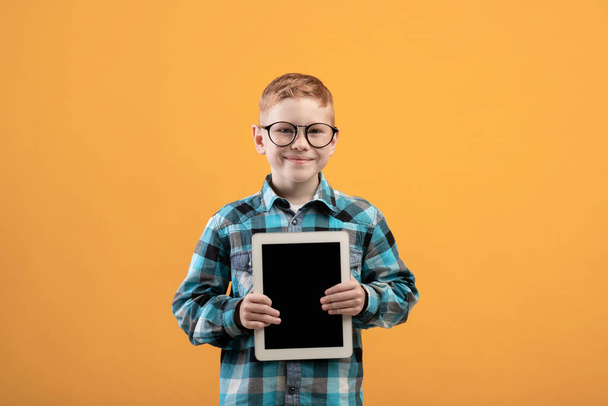 Imádnivaló fiú kezében digitális tabletta üres képernyőn - Fotó, kép