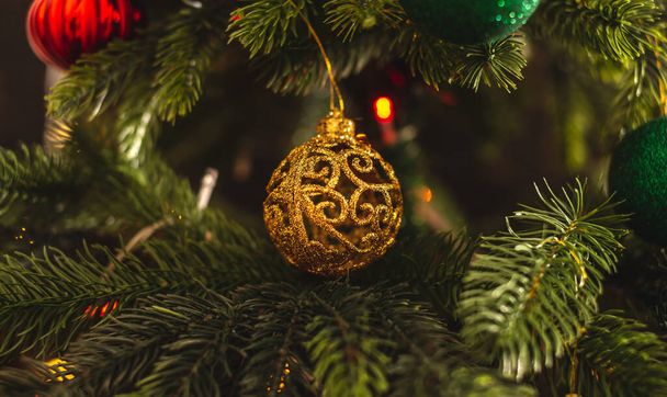 Bellissimo albero di Natale con giocattolo d'oro sui rami da vicino. Concetto di un'atmosfera Di Capodanno e umore festivo. - Foto, immagini