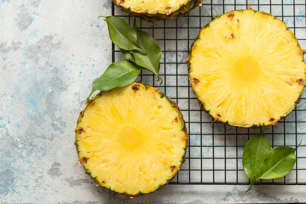 Reife Ananas in Scheiben geschnitten auf grauem Hintergrund - Foto, Bild