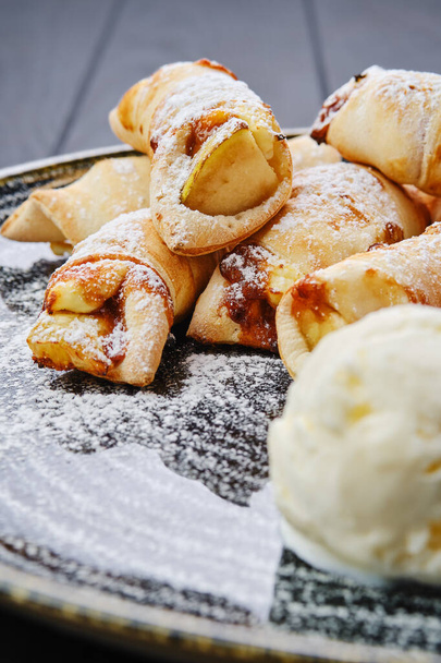 Close up view of baked pear wrapped in pastry with cinnamon served with ice cream - Zdjęcie, obraz