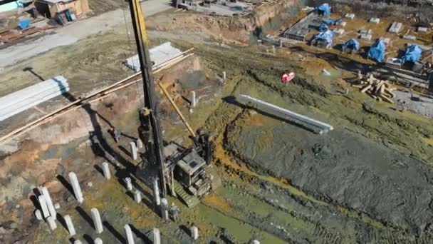 Vista aérea de una plataforma del conductor de pila en el sitio de construcción y la grúa en el día soleado - Metraje, vídeo
