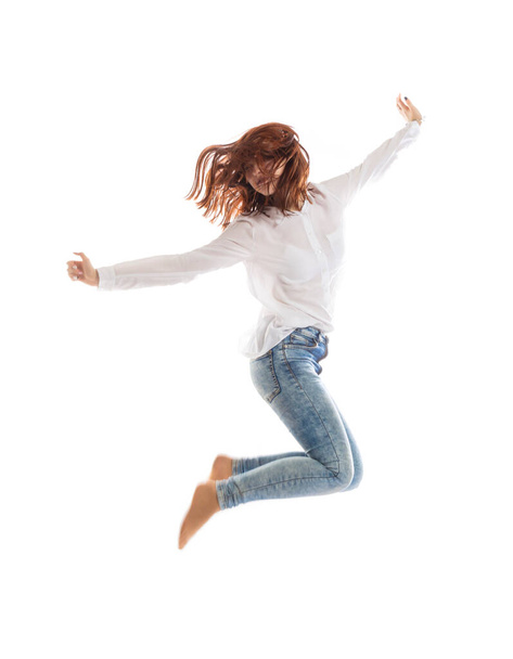 Teenage long hair girl jumping on white background. - Fotó, kép