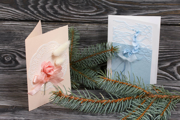 Greeting cards with elements of blue and pink shades. Spruce branch. On pine planks in black. - Foto, immagini