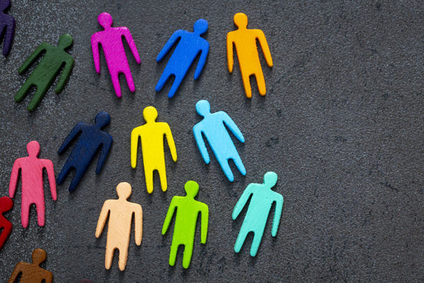 Concepto de igualdad y diversidad. Figuras de madera multicolores en una pizarra. - Foto, Imagen