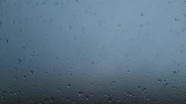 Капли дождя скользят по стеклу окна во время шторма внутри дома - Кадры, видео