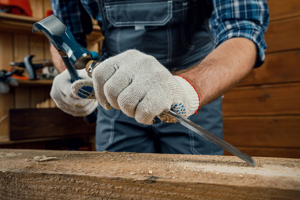 mâle charpentier marteaux bois avec un ciseau. outils de menuiserie - Photo, image