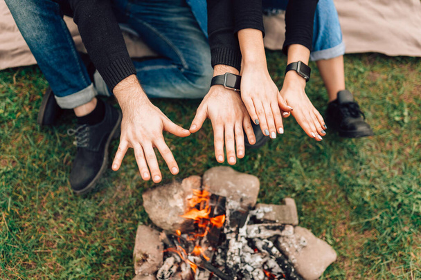 Romantic couple warming their hands over bonfire - Photo, Image