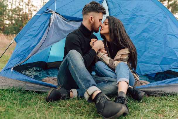 Couple of lovers kissing while sitting in tent - Photo, Image