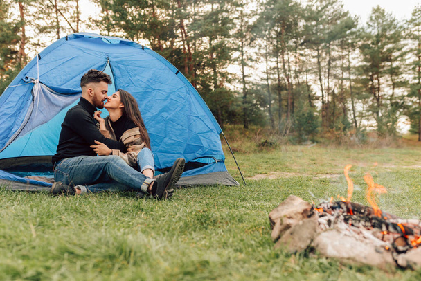 二人の恋人接吻しながらテントに座って - 写真・画像