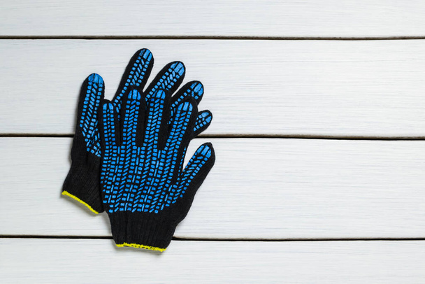 Προστατευτικά γάντια σε λευκό ξύλινο φόντο. - Φωτογραφία, εικόνα