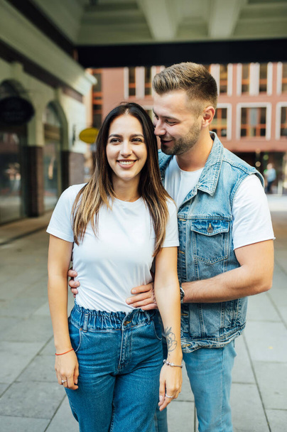 Fashion outdoor romantic portrait of beautiful young couple in love and hugs on the street. - Fotó, kép