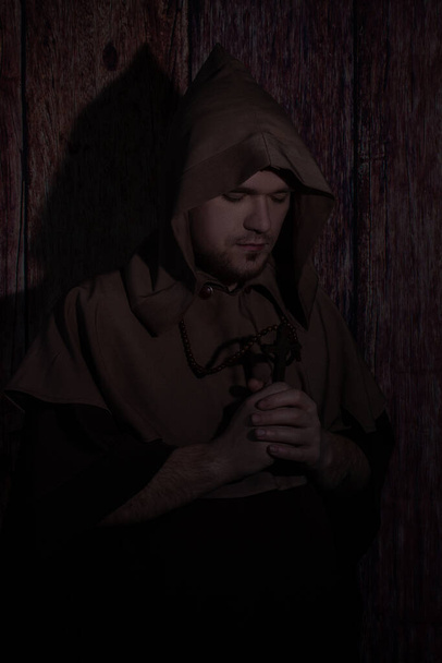 Monje medieval rezando con los ojos cerrados. misterioso monje católico - Foto, Imagen