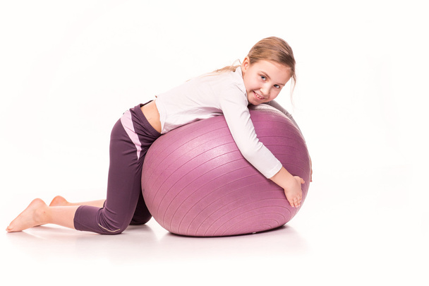 Sportive girl on a fit ball isolated over white - Foto, imagen