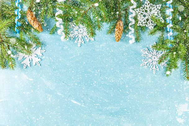 Vánoce nebo Nový rok pozadí se zelenými jedlovými větvemi a kužely na modrém pozadí. Zimní koncept, pohled shora, kopírovací prostor - Fotografie, Obrázek