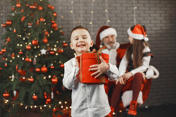 Santa and children around the decorated Christmas tree - Valokuva, kuva