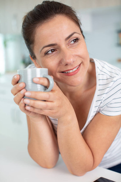 portrait of an attractive brunette with a mug - Foto, Bild