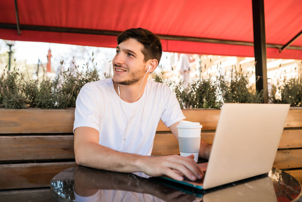 Young man using his laptop in a coffee shop. - Φωτογραφία, εικόνα