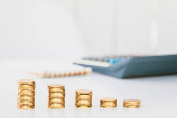 Pénzügyi számlák és érmék számológéppel az asztalon naplemente fény fókusz. - Fotó, kép