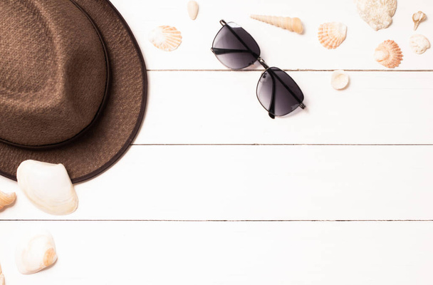 Chapéu marrom, óculos e concha em madeira branca da mesa, espaço de cópia para o seu text.Summer fundo - Foto, Imagem