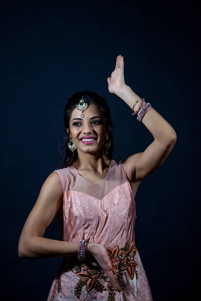 Ritratto di bella ragazza indiana sorridente. giovane modello femminile indossa set di gioielli e abiti rosa tradizionali - Foto, immagini
