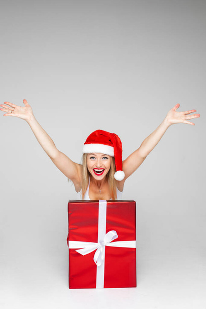 Happy woman bursting out of a fancy Christmas present - Foto, afbeelding