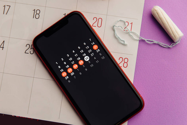 Menstruační aplikace v chytrém telefonu s bavlněným tamponem. Žena kritické dny a koncepce hygienické ochrany - Fotografie, Obrázek