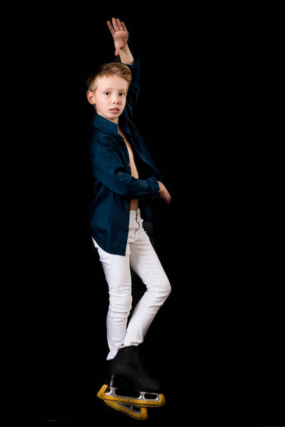 Jonge kunstschaatser gekleed in witte jeans en blauw shirt - Foto, afbeelding