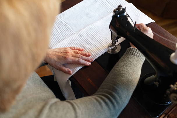 Idős nő használ egy vintage varrógép otthon - Fotó, kép