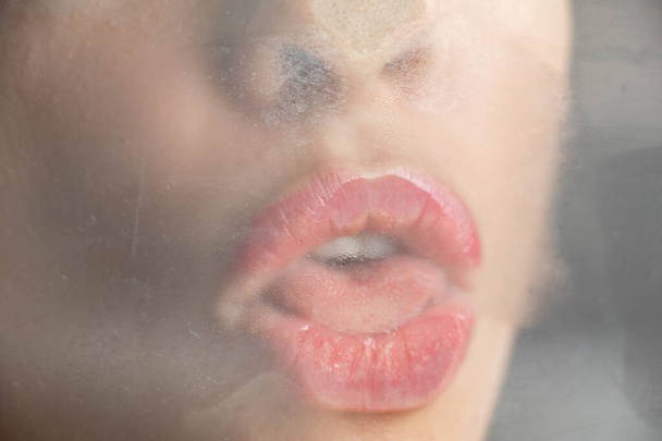 young sexy girl kissing misted glass close up - Foto, Bild