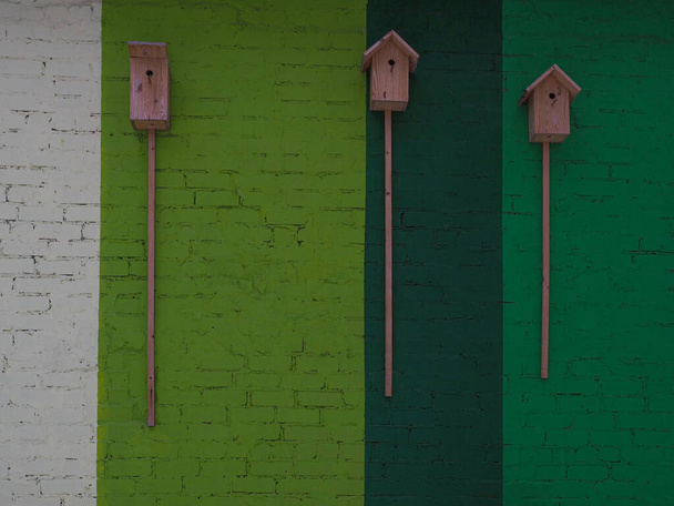 Casas de pájaros sobre un fondo texturizado de una pared de ladrillo pintado multicolor. - Foto, imagen