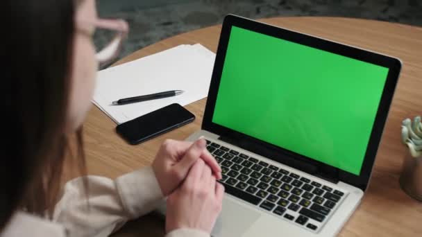 Πάνω από τον ώμο closeup άποψη της γυναίκας εργασίας από το σπίτι βίντεο καλώντας με πράσινη οθόνη και μιλώντας κάποιος στην οθόνη του φορητού υπολογιστή.work από το σπίτι έννοια. - Πλάνα, βίντεο