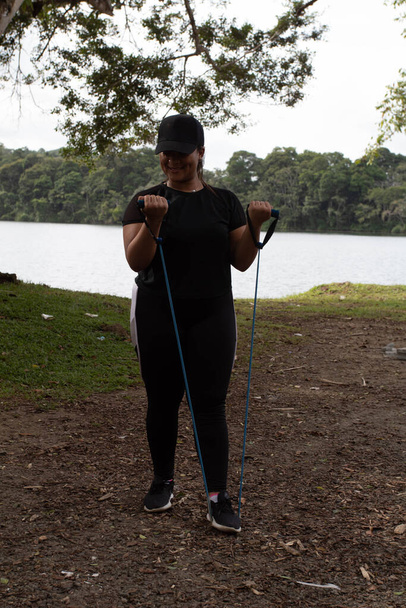 giovane donna nera che esercita da un lago con giarrettiere - Foto, immagini