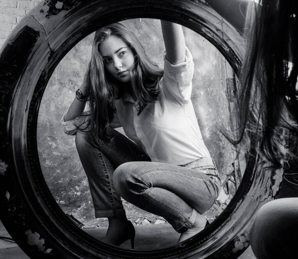Beautiful young woman looking on her reflection at the mirror - Photo, Image