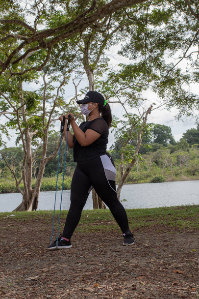jeune femme noire faisant de l'exercice près d'un lac avec des jarretières - Photo, image