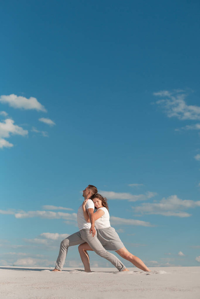 Романтична пара танцює в пустелі на фоні блакитного неба
. - Фото, зображення
