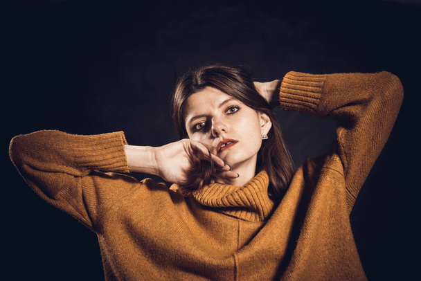 Studio portrait of young beautiful woman dressed in sweater - Foto, afbeelding
